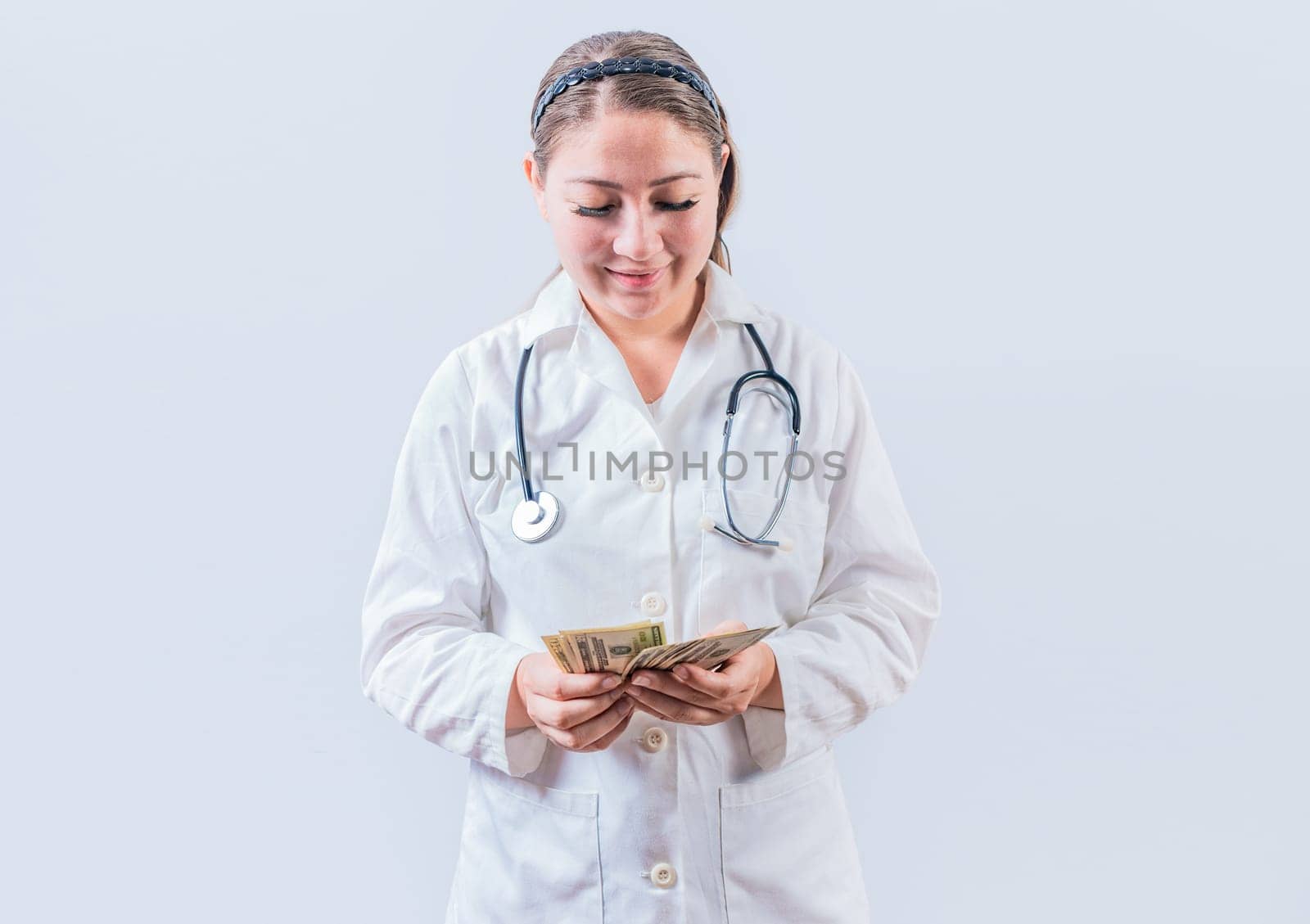 Corrupt female doctor counting money isolated. Female doctor counting banknotes on white background. Medical corruption concept