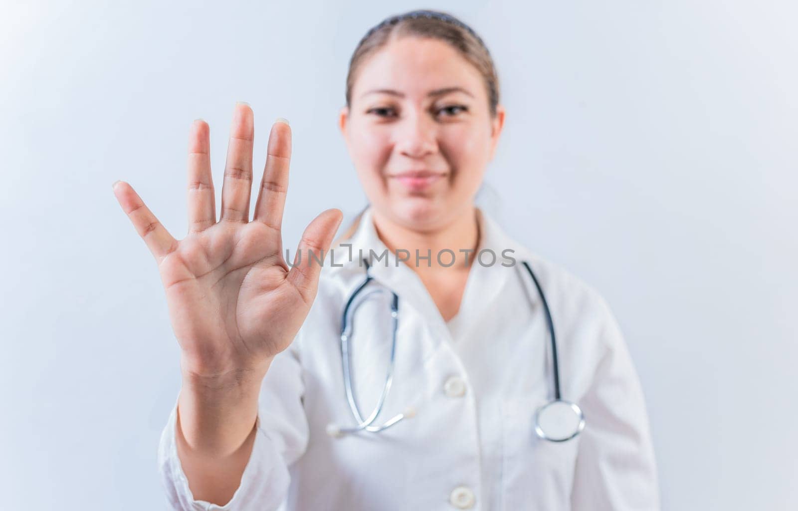 Female doctor counting number FIVE isolated. Young female doctor counting number 5 on isolated background
