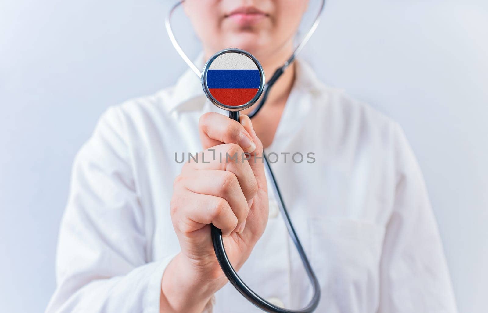 Female doctor holding stethoscope with with Russia flag. Russia health and care concept