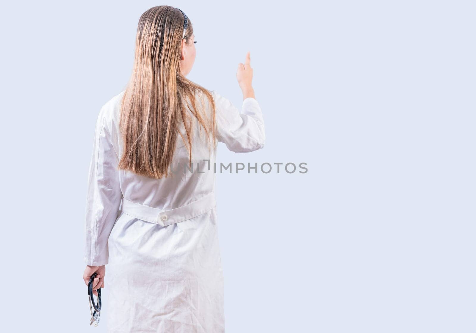 Rear view of female doctor pointing isolated. Young female doctor from behind pointing finger isolated