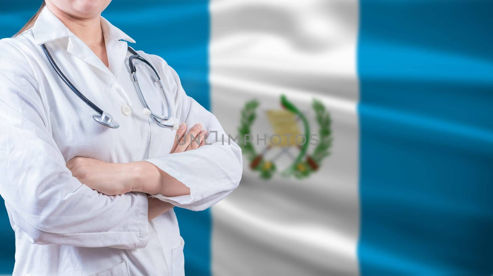 Healthcare concept with Guatemalan flag in background. Doctor with arms crossed with Guatemala flag background