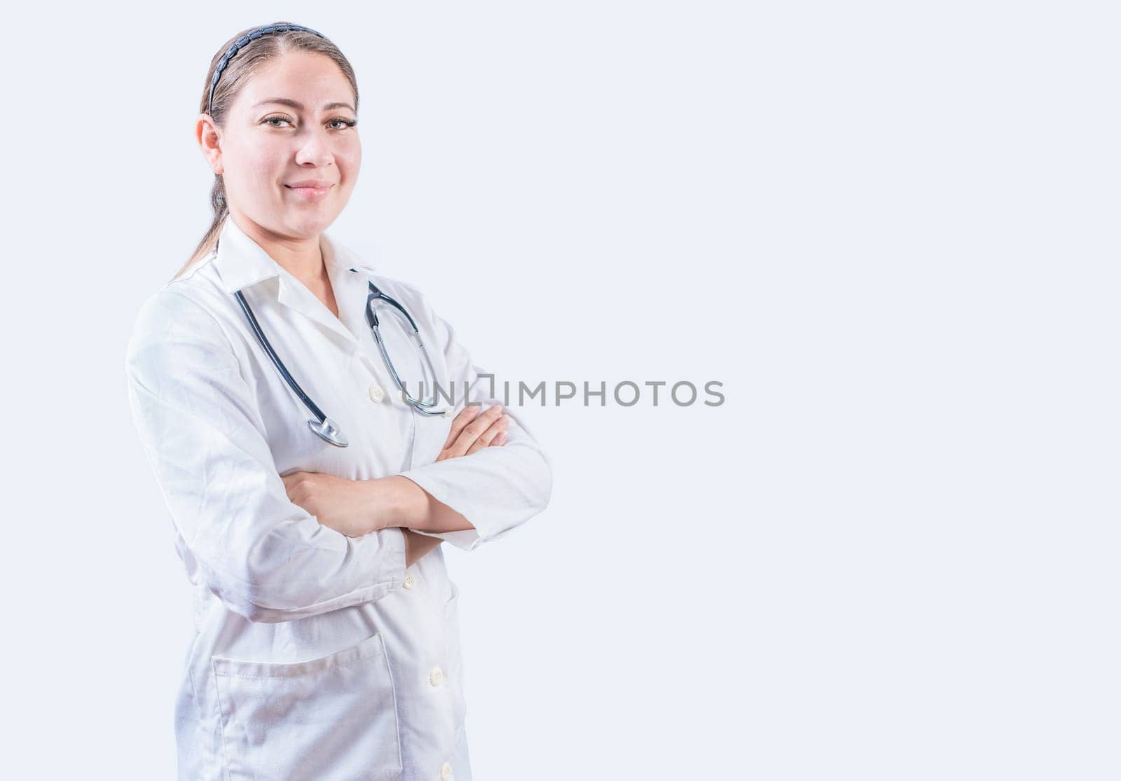 Portrait of smiling female doctor with crossed arms isolated. Successful female doctor with arms crossed isolated