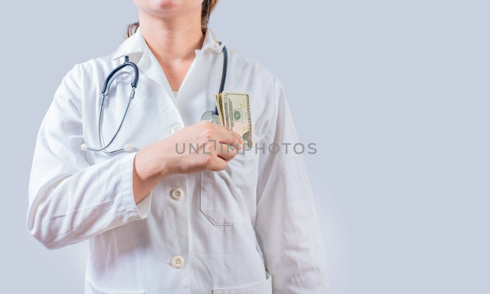 Unrecognizable doctor putting bribe money in pocket isolated. Dishonest female doctor putting money in pocket. Medical bribery concept