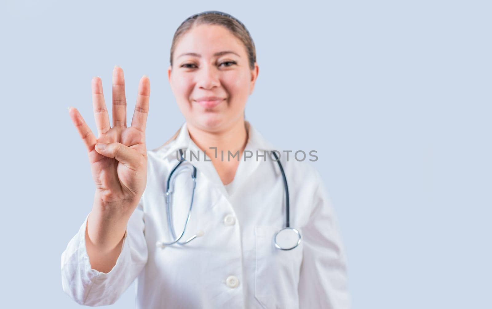 Female doctor counting number FOUR isolated. Young female doctor counting number 4 on isolated background