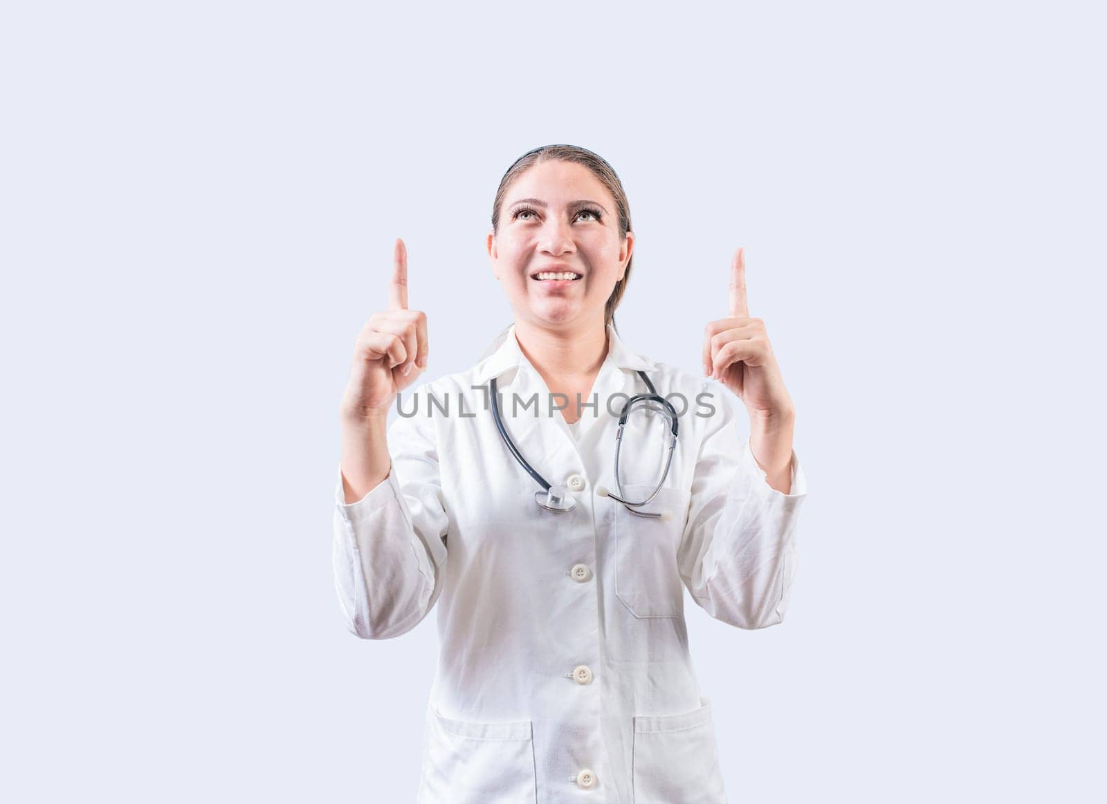 Happy female doctor pointing a promotion up. Smiling female doctor looking and pointing up isolated