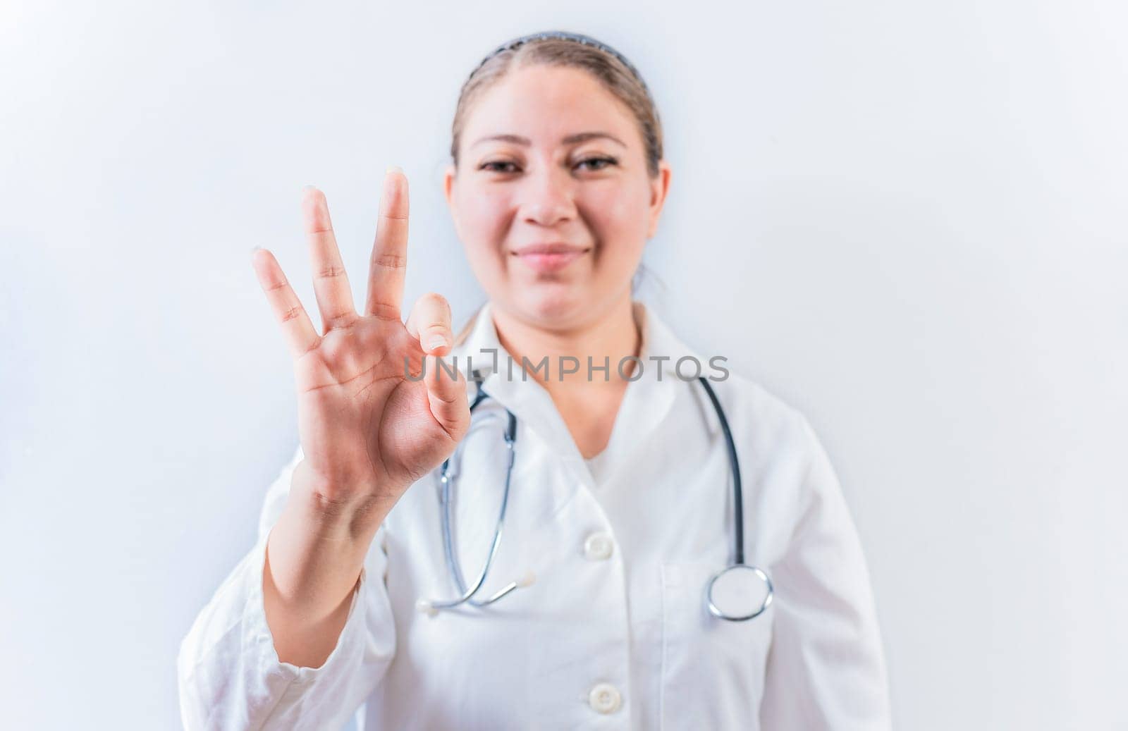 Female doctor counting number THREE isolated. Young female doctor counting number 3 on isolated background