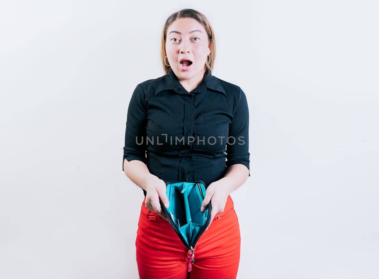 Shocked young woman showing empty wallet isolated. Unemployed girl without money showing empty wallet