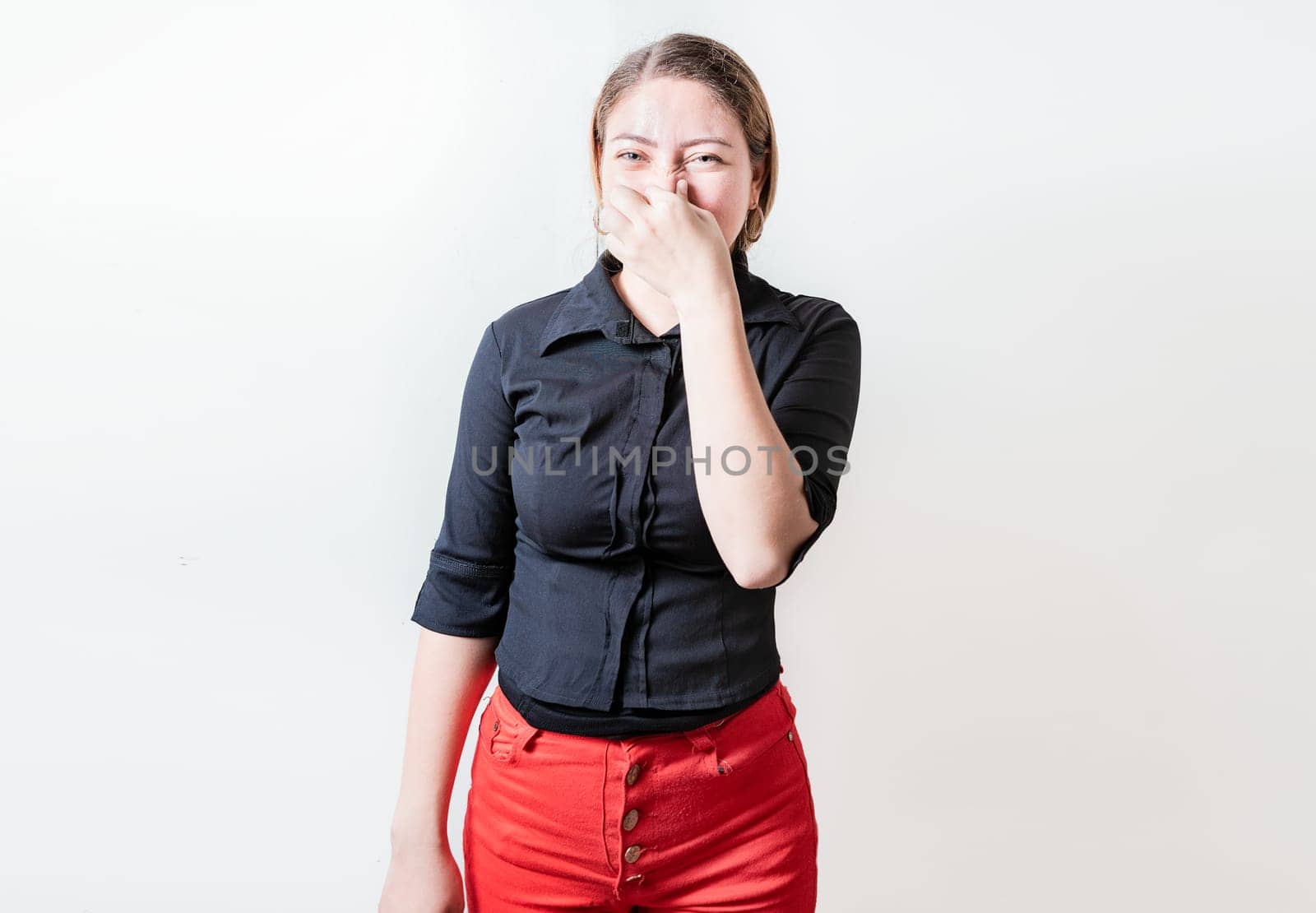 Displeased person holding her nose isolated. Disgust young girl covering nose. Woman covering nose from a bad smell isolated