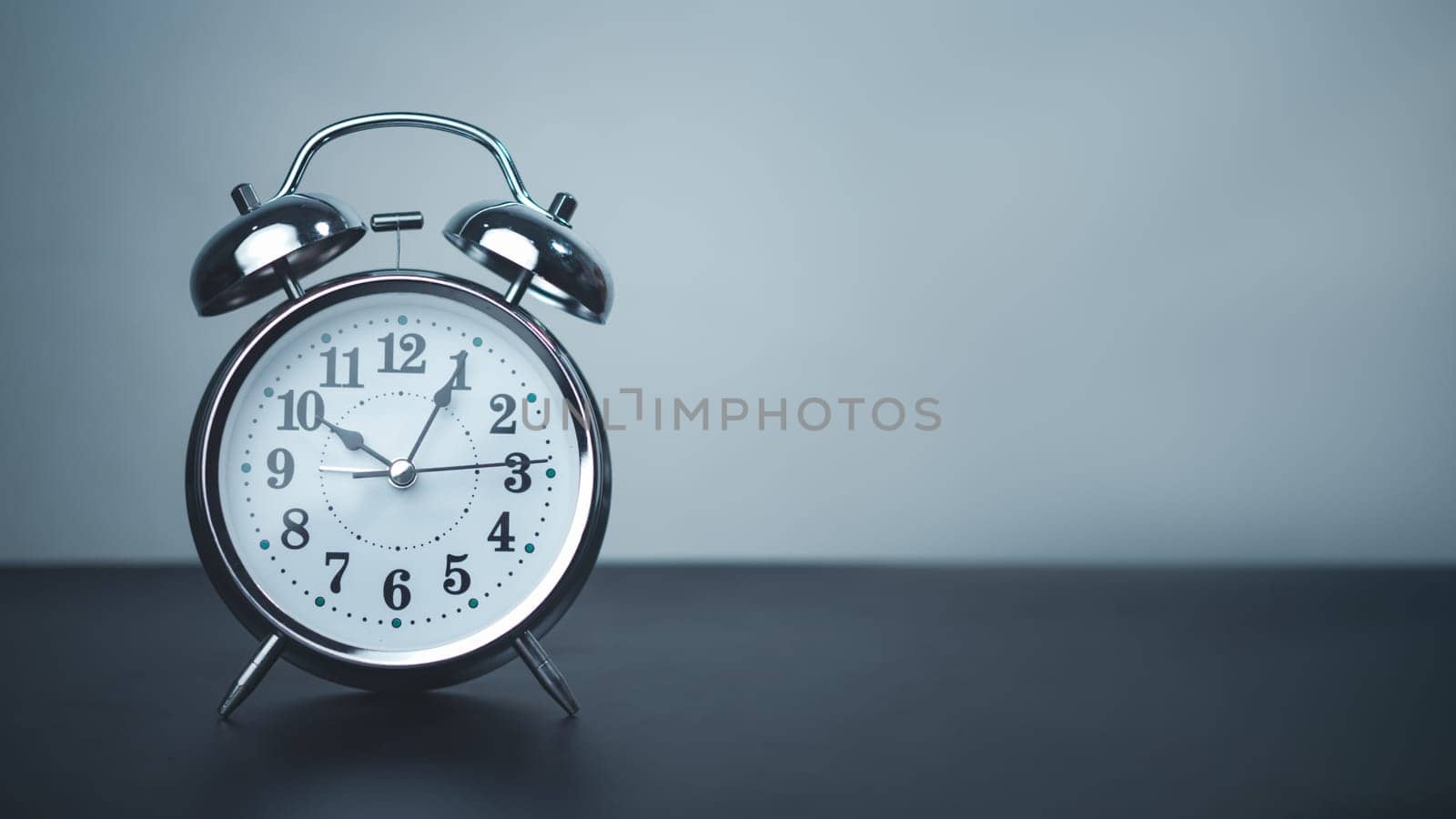 White alarm clock on black table with copy space for preparation of Merry Christmas and Happy new year concept, Start new business, Start up, New trend to next year concept.
