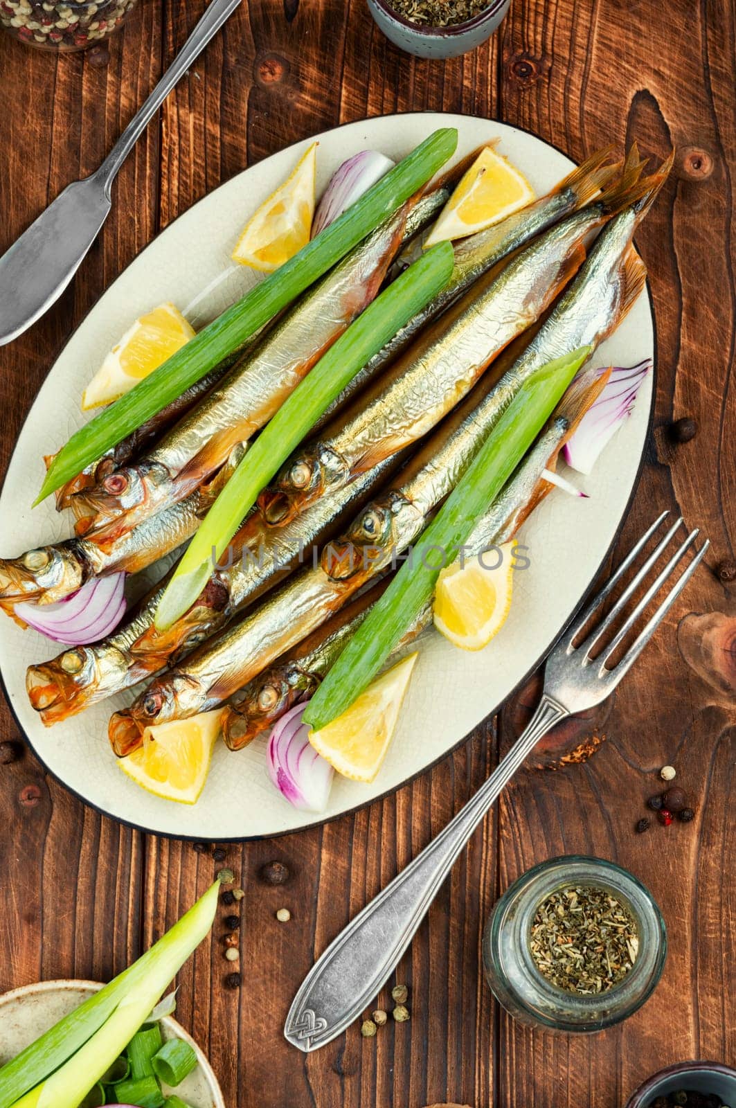 Golden smoke, dried fish. Plate with delicious smoked capelin.