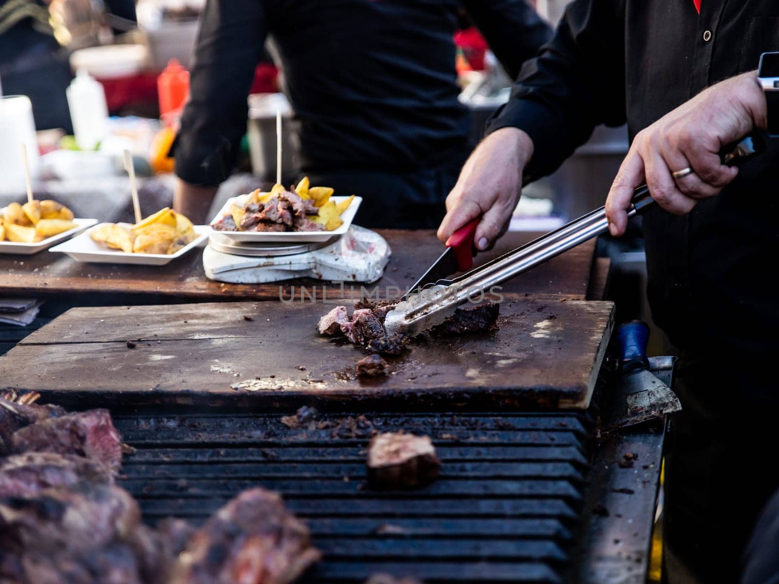 Some excellent pieces of Argentinian beef on a charcoal grill being prepared at open kitchen street food festival in Ljubljana, Slovenia