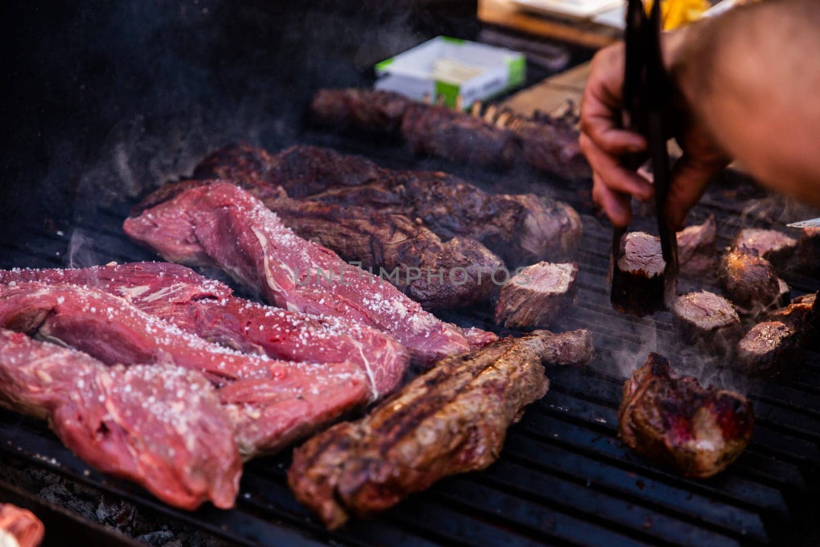 Some excellent pieces of Argentinian beef on a charcoal grill being prepared at open kitchen street food festival in Ljubljana, Slovenia