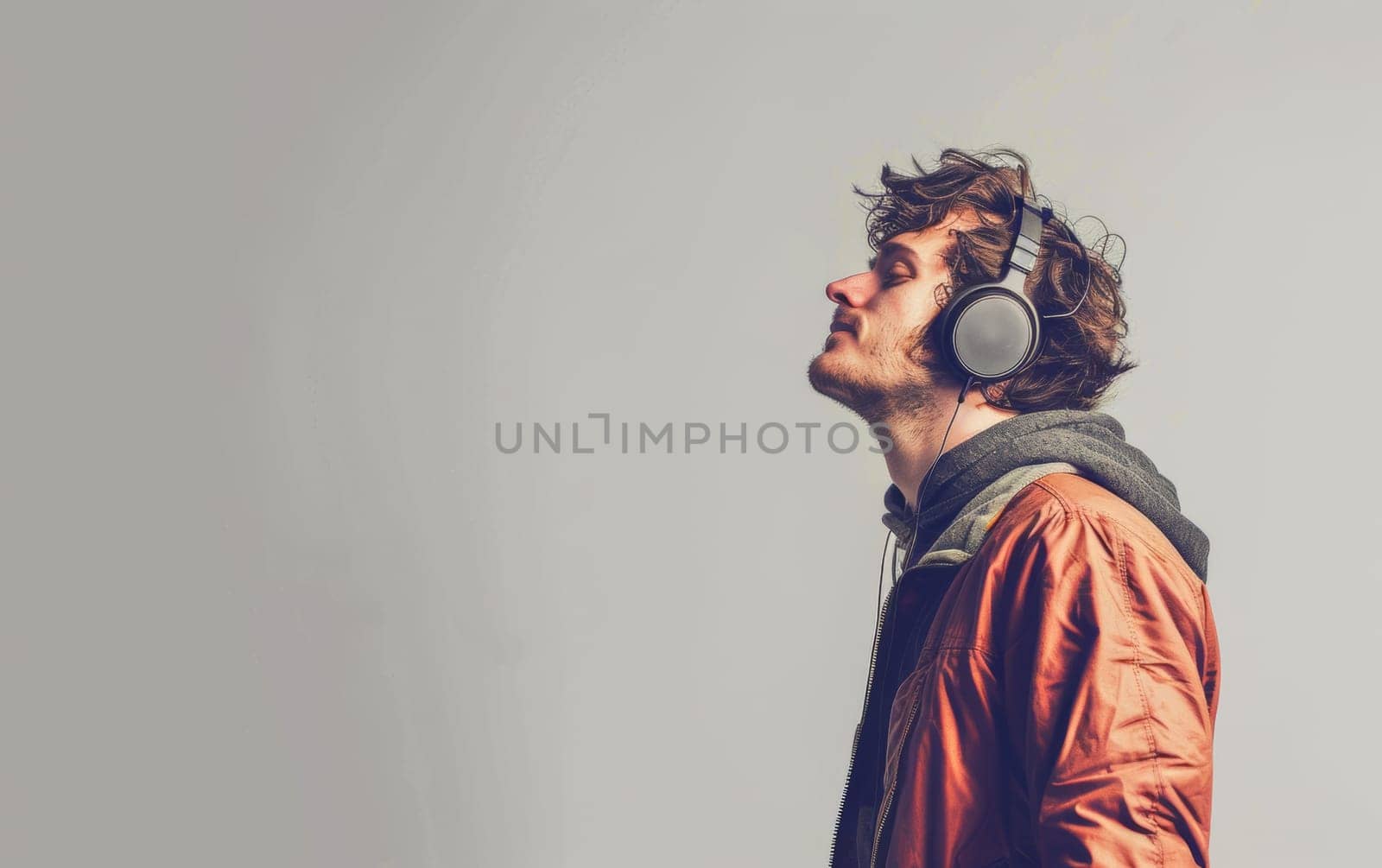 A man in an orange jacket is captured in a side profile, eyes closed in sheer musical ecstasy. The vibrant energy of the moment is palpable, as he immerses himself in sound