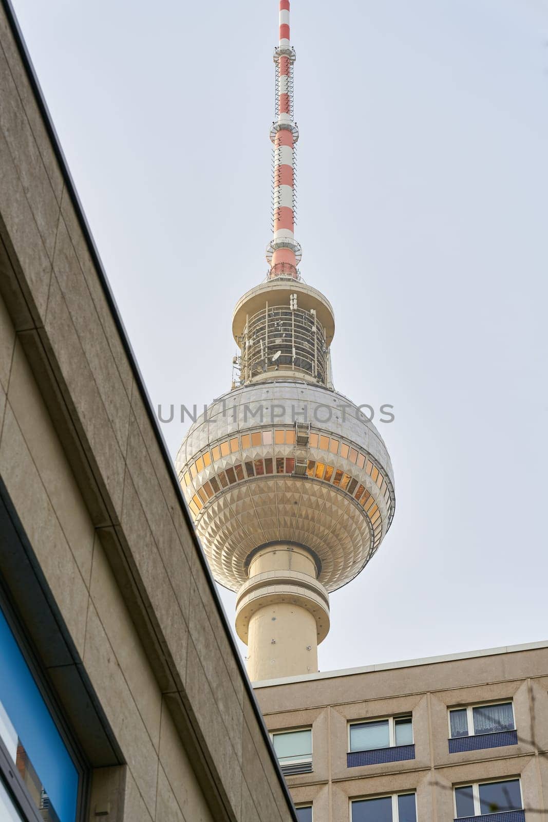 The television tower in Berlin from an unusual perspective hidden behind prefabricated buildings