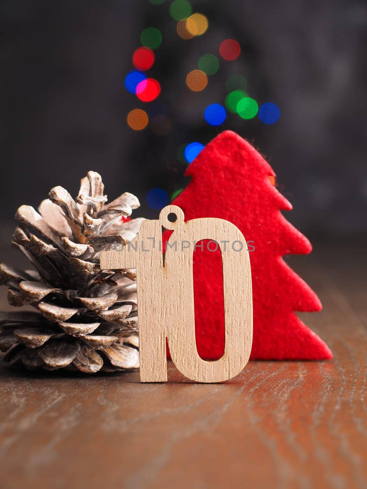 Tenth December Wooden number ten with a red Christmas tree shape on blurred Christmas lights
