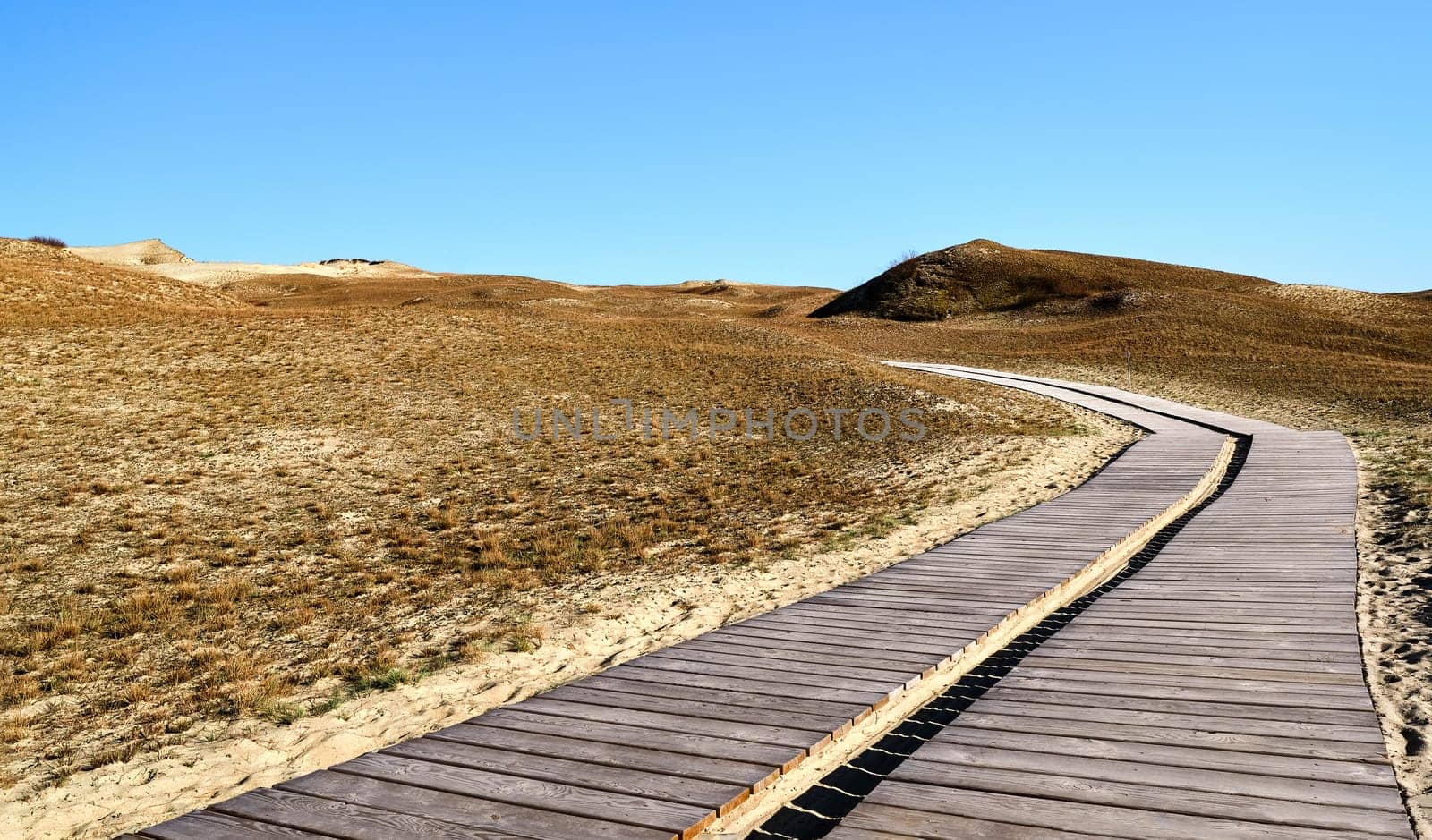 Nordic sand dunes and wooden pathway, Baltic sea, Curonian spit, Nida, Klaipeda, Lithuania at sunset. Lines, rhythm and patterns of shadows and hills