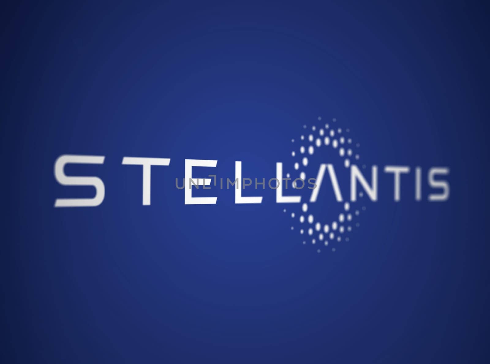 Amsterdam, NL, May 2023: White Stellantis logo on a blue background. Multinational automotive manufacturing corporation. Illustrative editorial. Illustration. Selective focus