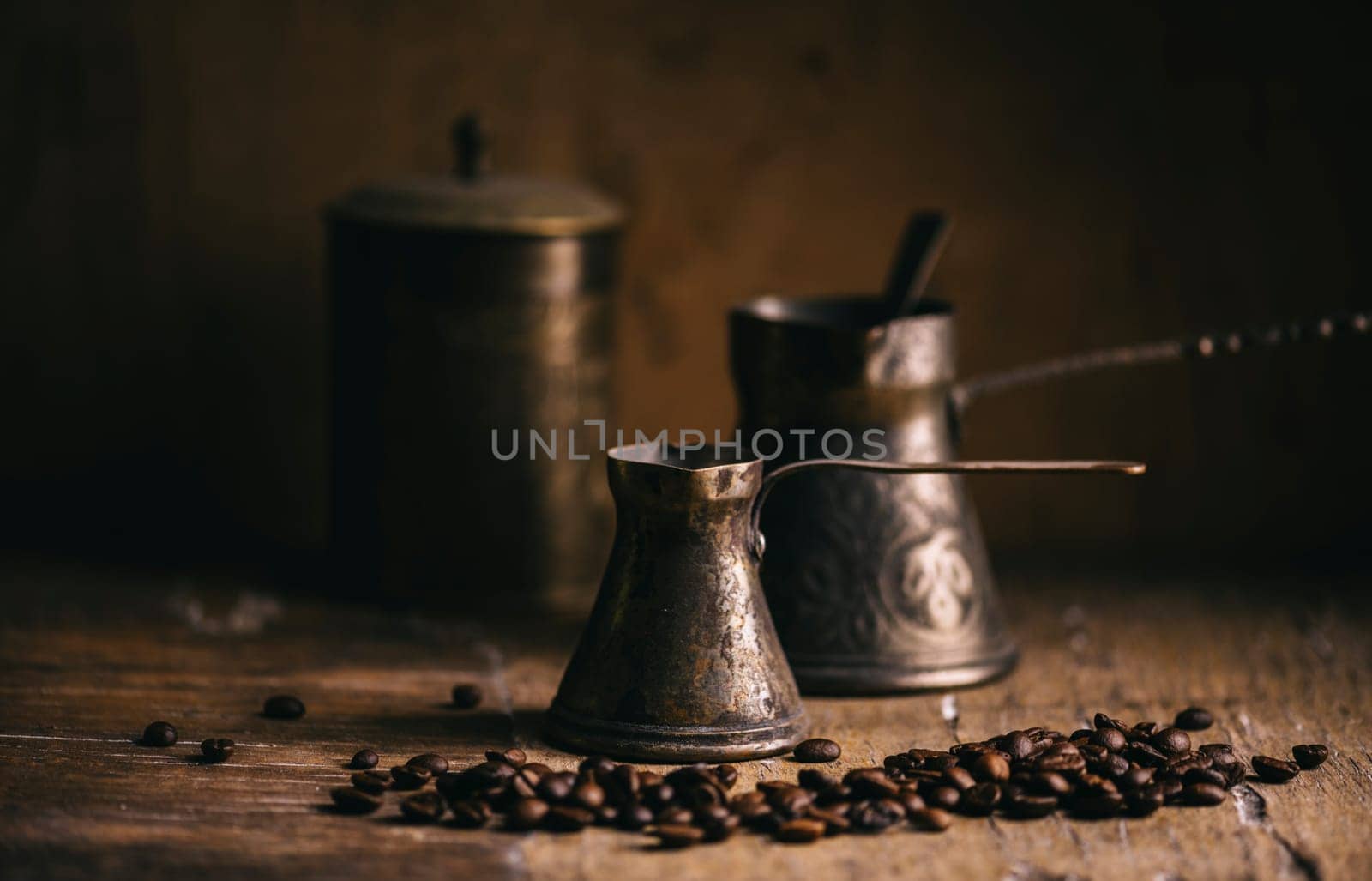 Old coffee pot and coffee bean on rustic wooden table. Vintage oriental coffee on dark background. Still life.