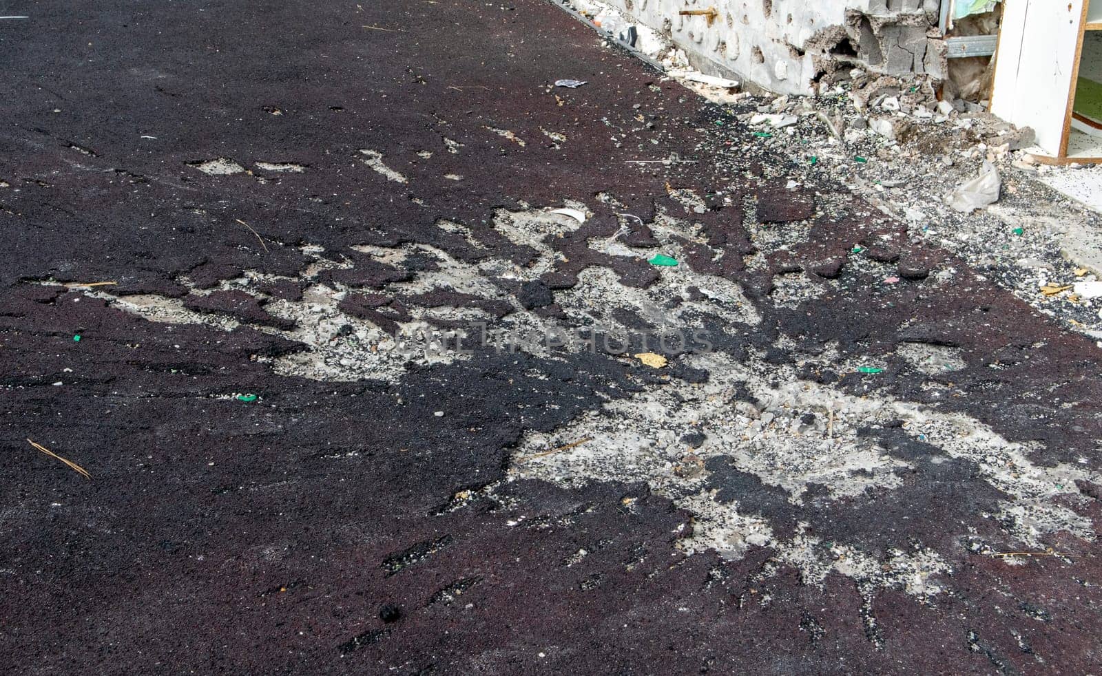 War in Ukraine. Funnel from the explosion in the asphalt. The trace left by the explosion of an artillery shell. Consequences of the rocket attack