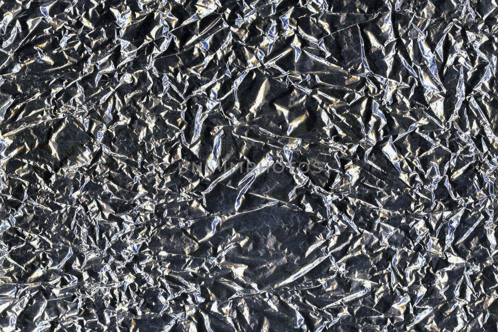Silver crumpled aluminum foil flat background and texture. Shiny surface