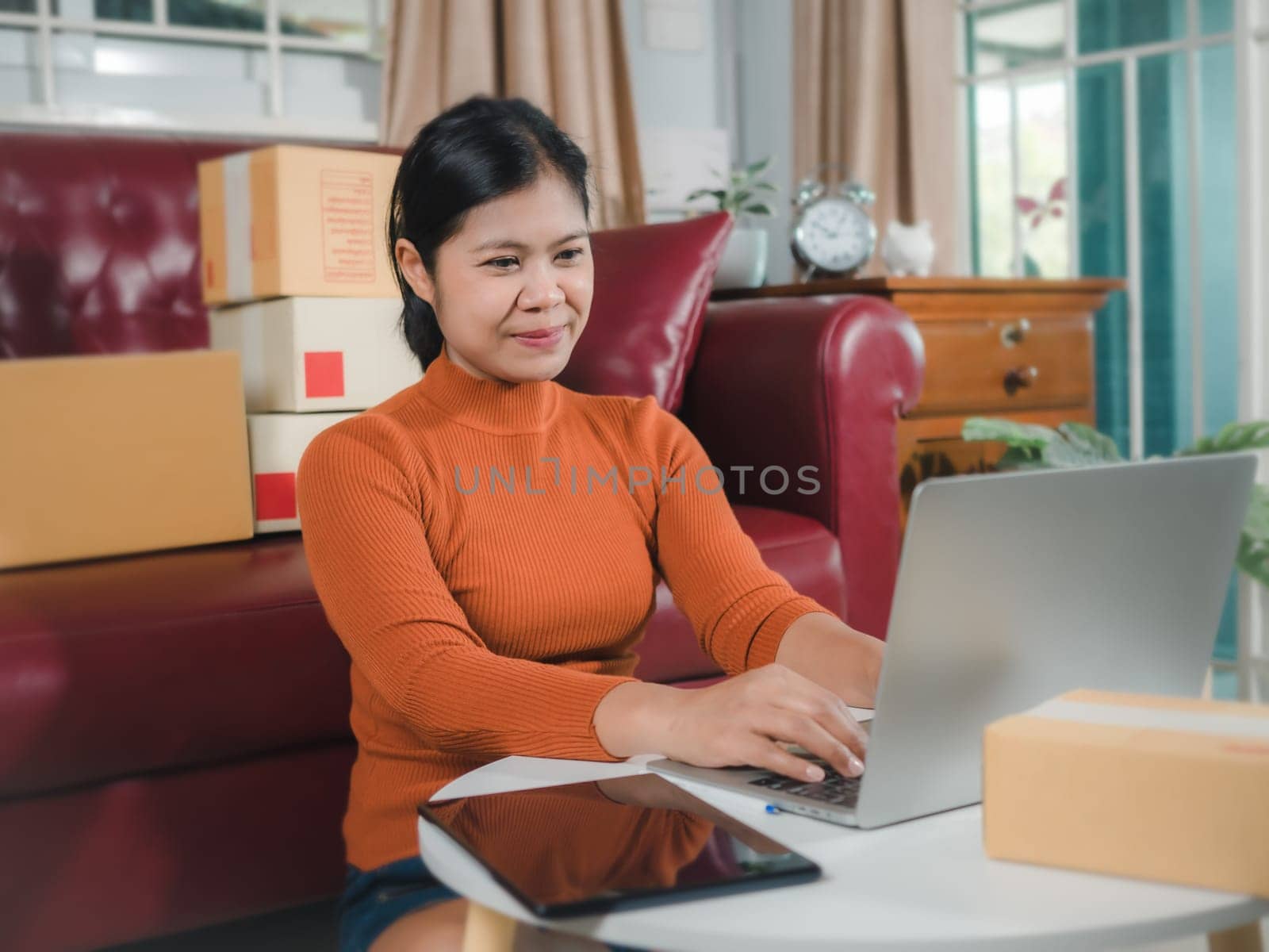 Asia women working business SME online at home her checking order from laptop for customer and online delivery for ready packing, Checking orders from customers with digital laptop, Small business.