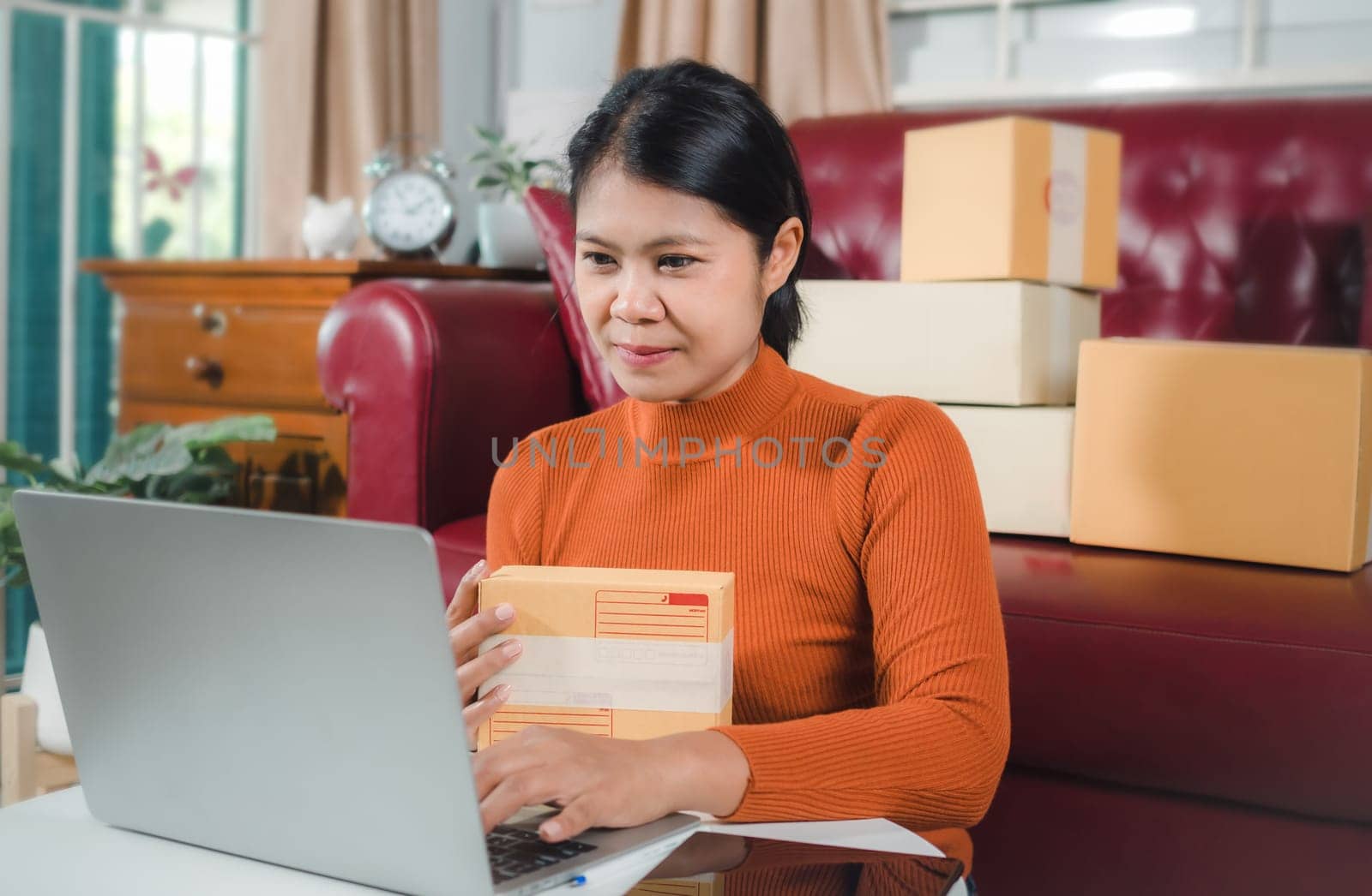 Asia women working business SME online at home her checking order from laptop for customer and online delivery for ready packing, Checking orders from customers with digital laptop, Small business.
