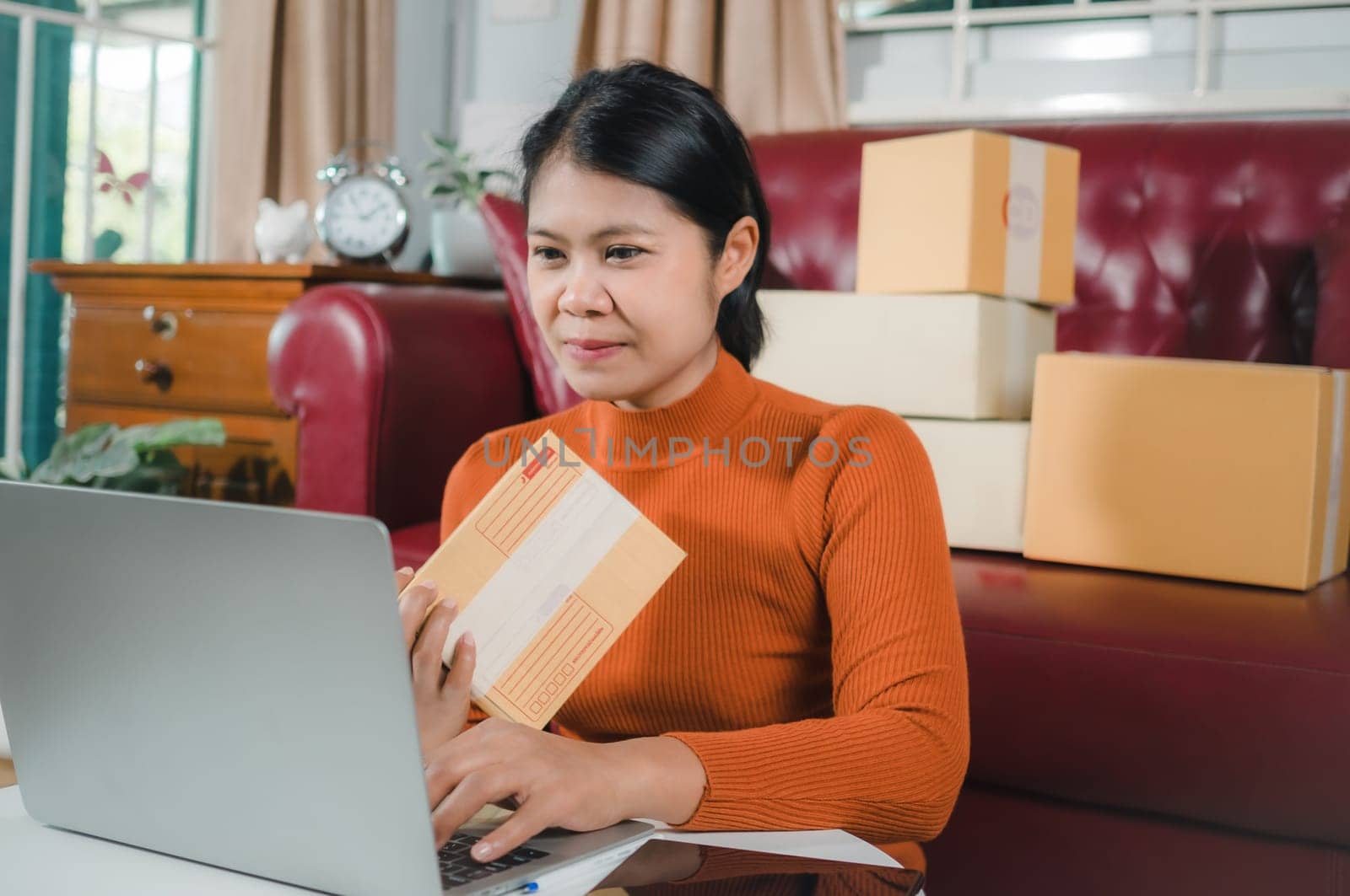Asia women working business SME online at home her checking order from laptop for customer and online delivery for ready packing, Checking orders from customers with digital laptop, Small business.