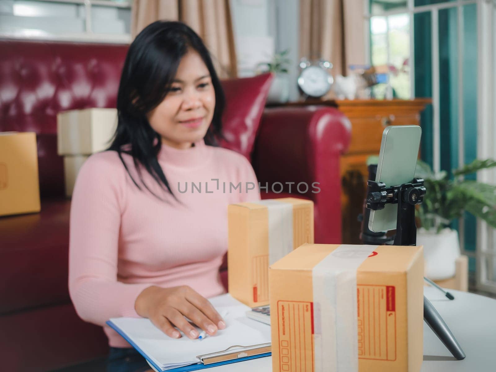 Asian blogger review products and video camera on her phone, sell them online, Business online influencer on social media concept, Ecommerce business live streaming vlog new normal concept.