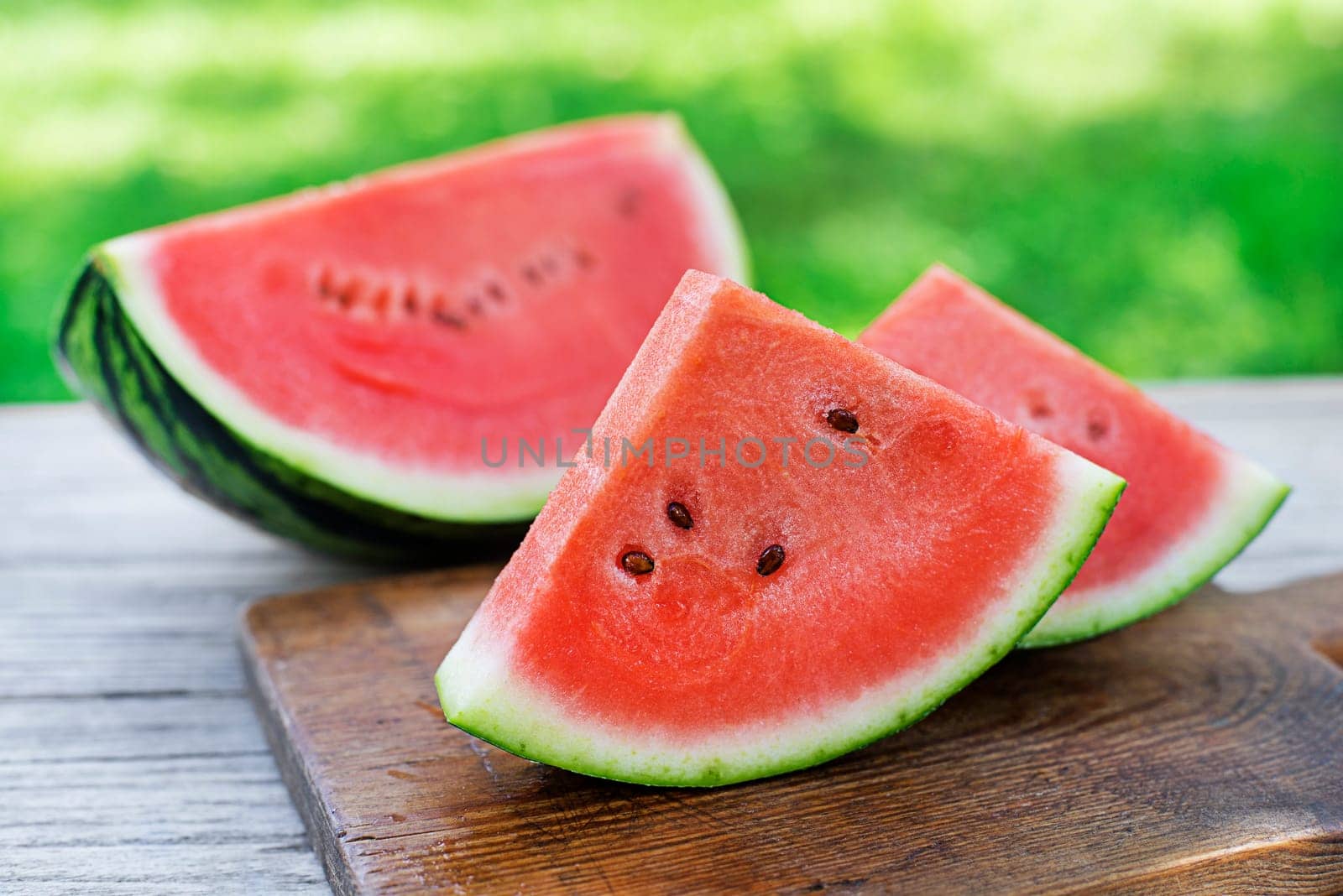 Fresh sliced watermelon in wooden table background outdoors