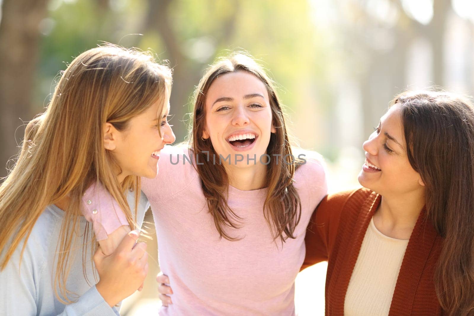 Happy woman between friends with perfet smile looks at you in the street