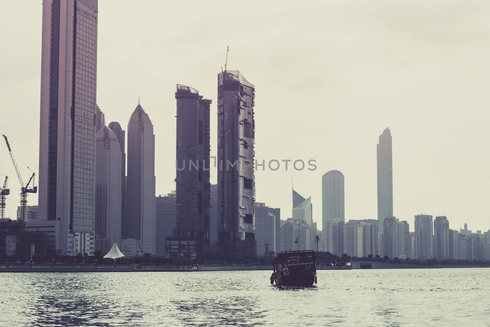 Abu Dhabi buildings skyline with old fishing boat on the front