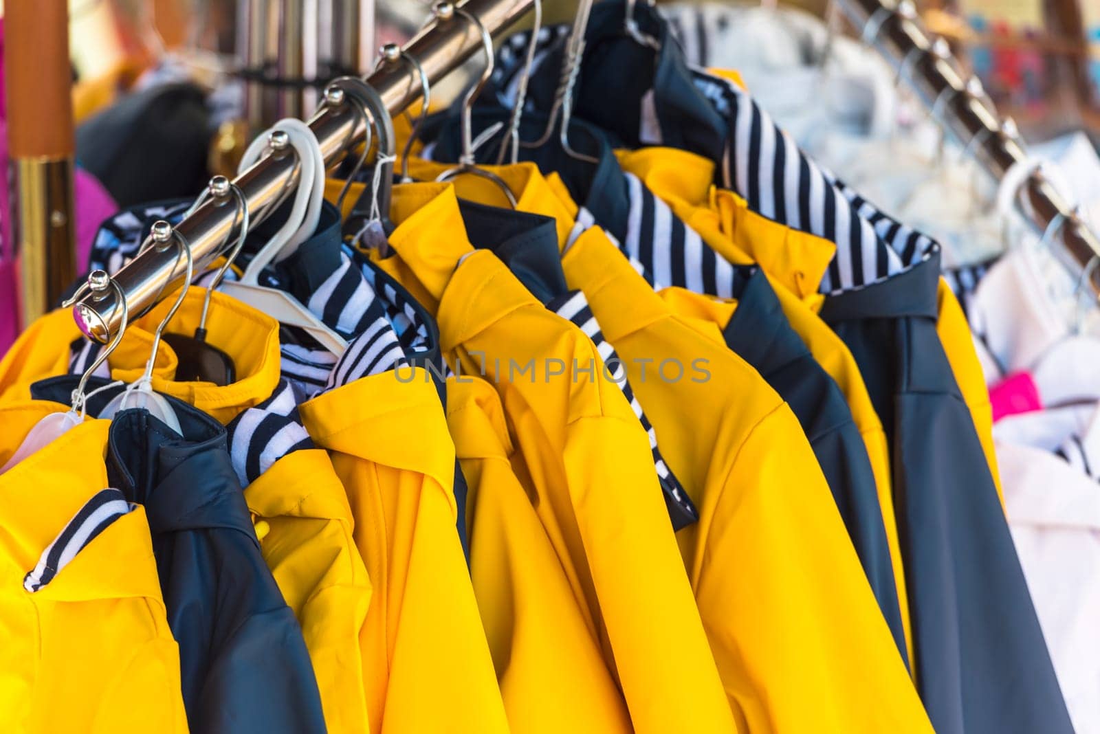 Bright autumn raincoats hanging at a fashion store
