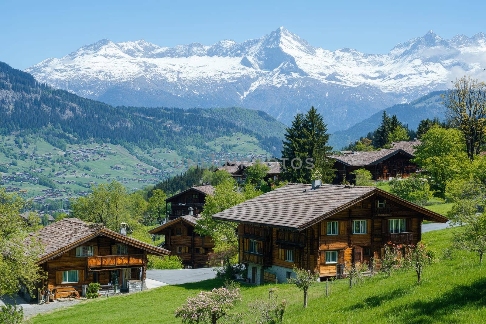 Idyllic Swiss mountain village with traditional wooden chalets against backdrop of snow-capped Alps on sunny day.
