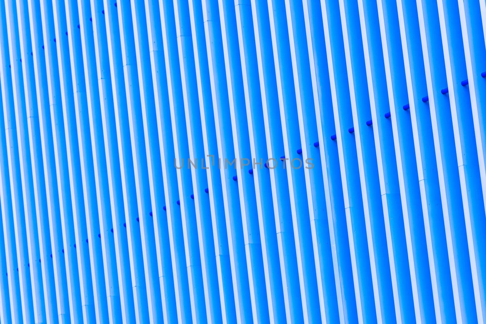 Detail of pattern striped metal facade for blue background