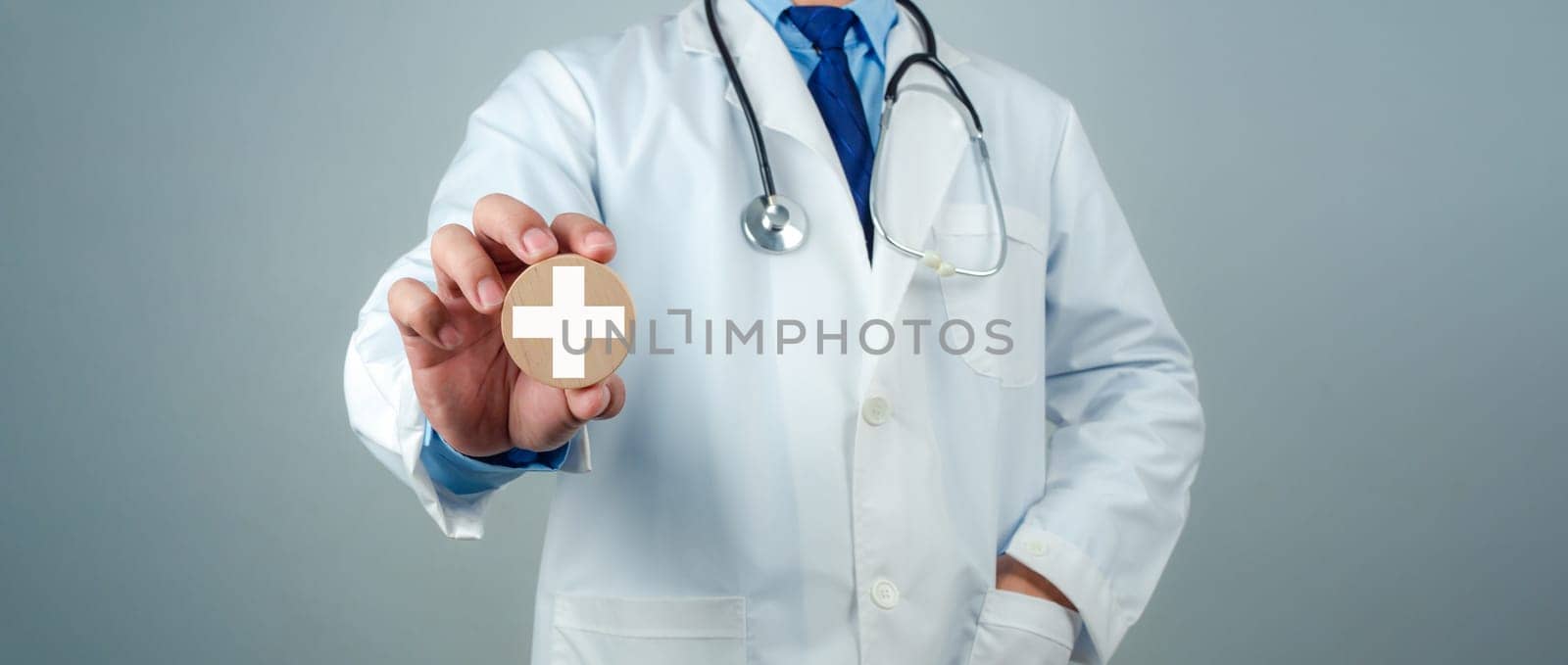 Doctor showing circle wood plank and plus sign represents medical health care and doctor staff service concept, Insurance in health care and medicine concept.