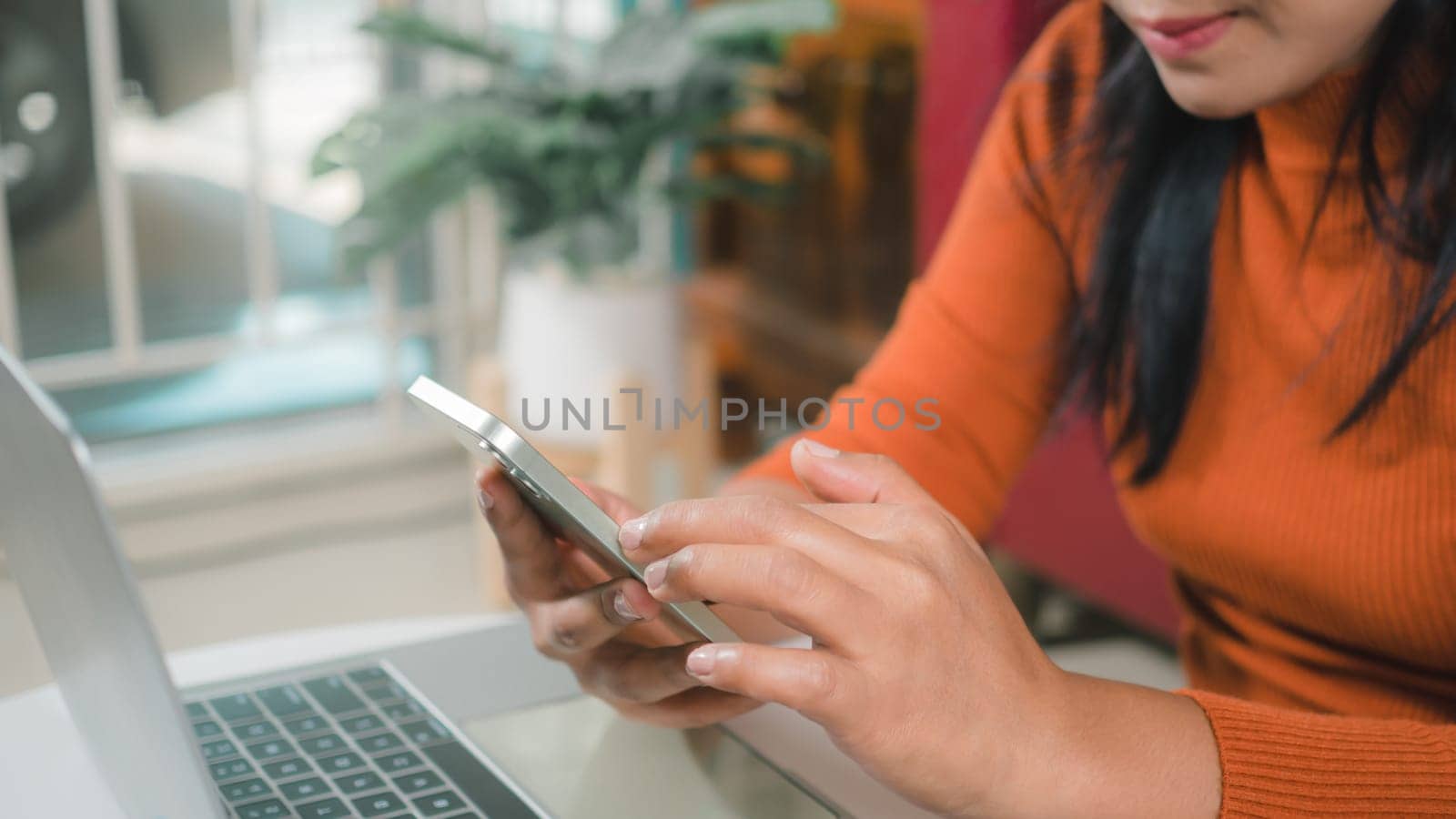 Asia women working business SME online at home her checking order from smartphone  for customer and online delivery for ready packing, Checking orders from customers with digital laptop.
