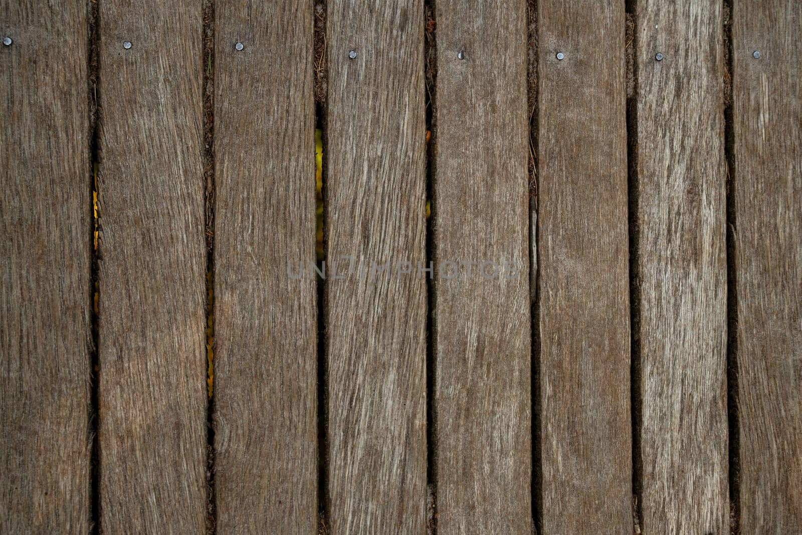 Close up of old abandoned rickety foot bridge. Old wood texture background coming from natural tree. The wooden panel has a beautiful dark pattern.