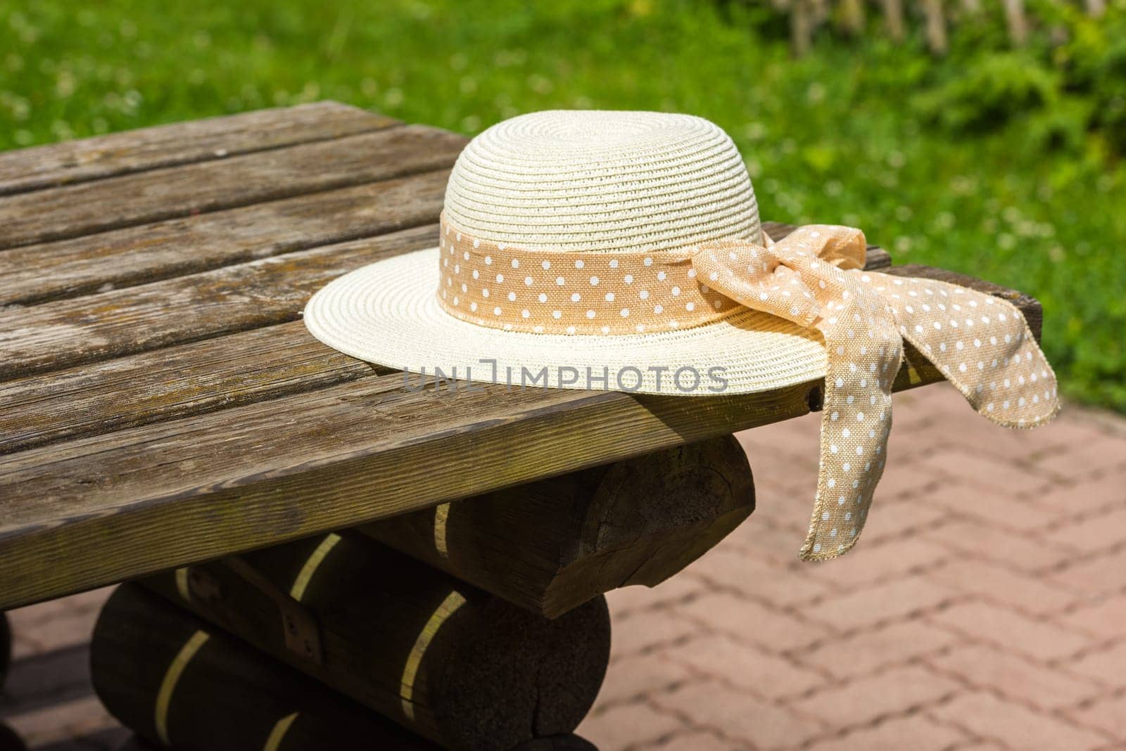 Female summer hat laying on the wooden rustic table. Selective focus shot