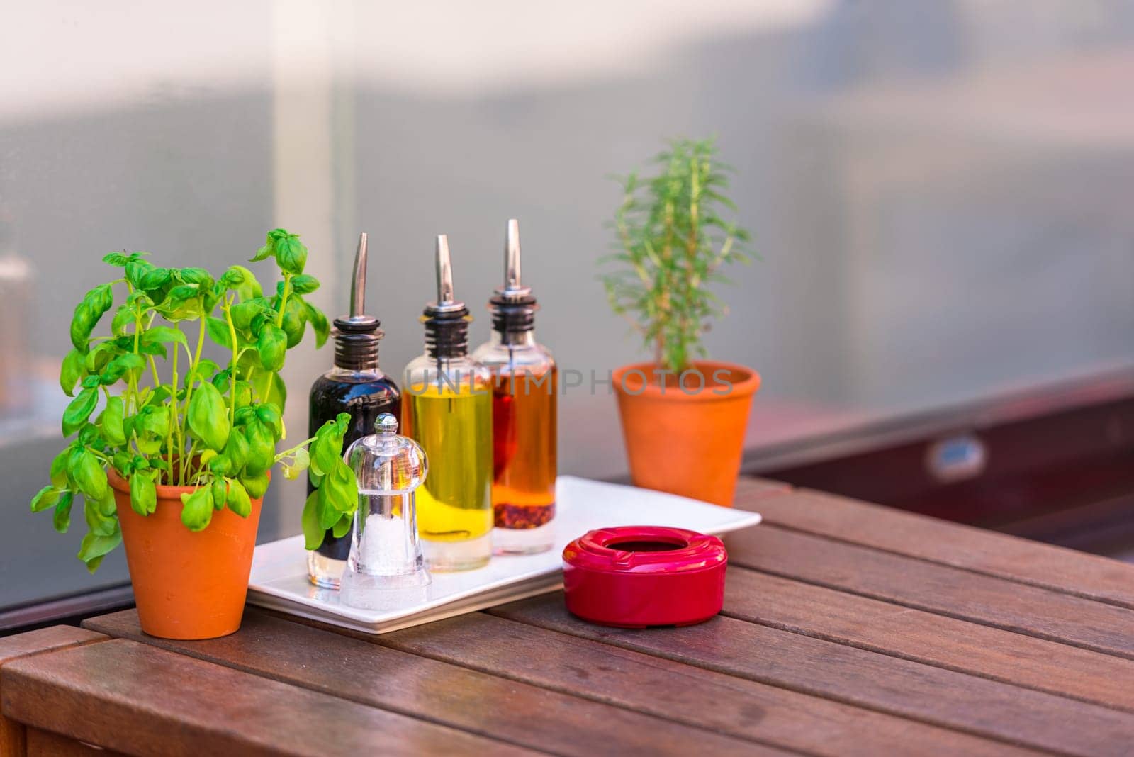 Balsamic vinegar and oil bottles and condiments on the table in an outdoor cafe