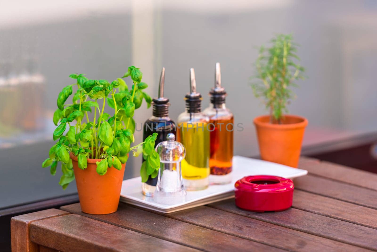 Balsamic vinegar and oil bottles and condiments on the table in an outdoor cafe