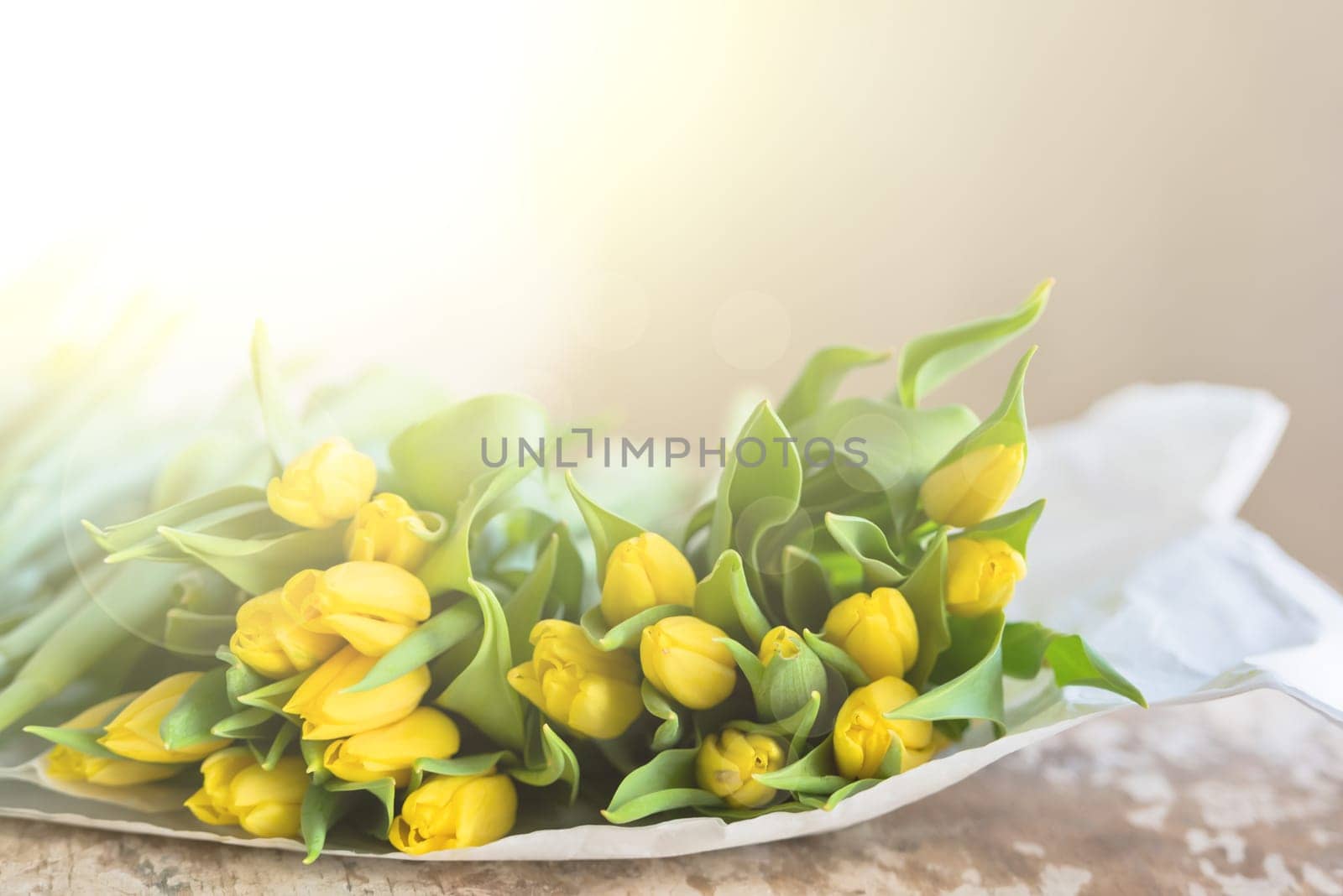 Yellow tulips flowers bouquet on a wooden table