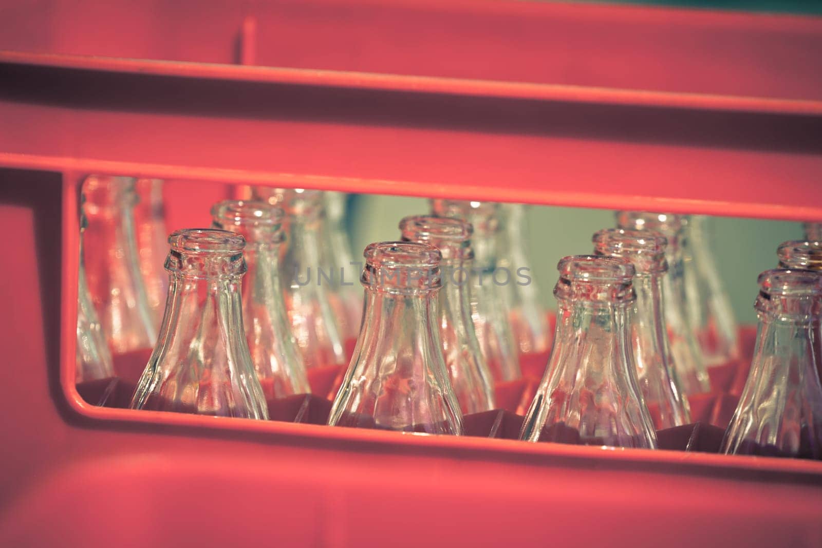 Red Plastic Crate with Empty Glass Bottles. Horizontal filtered shot