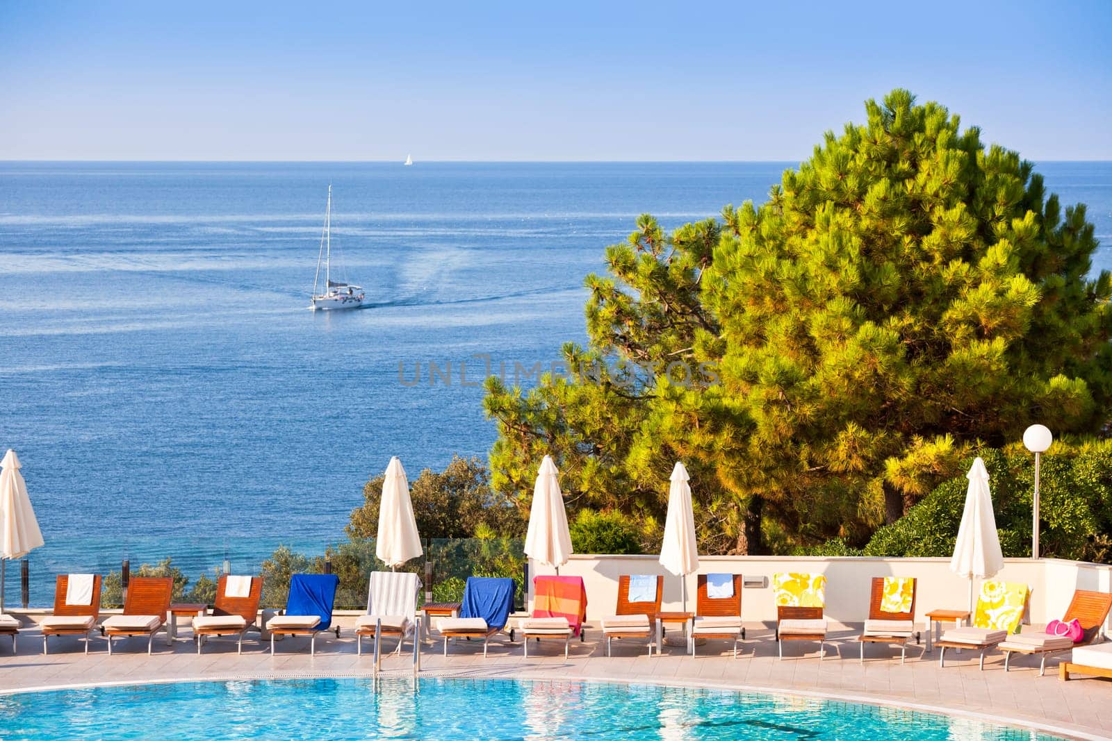 Sunbeds and umbrellas by the swimming pool on a sunny day