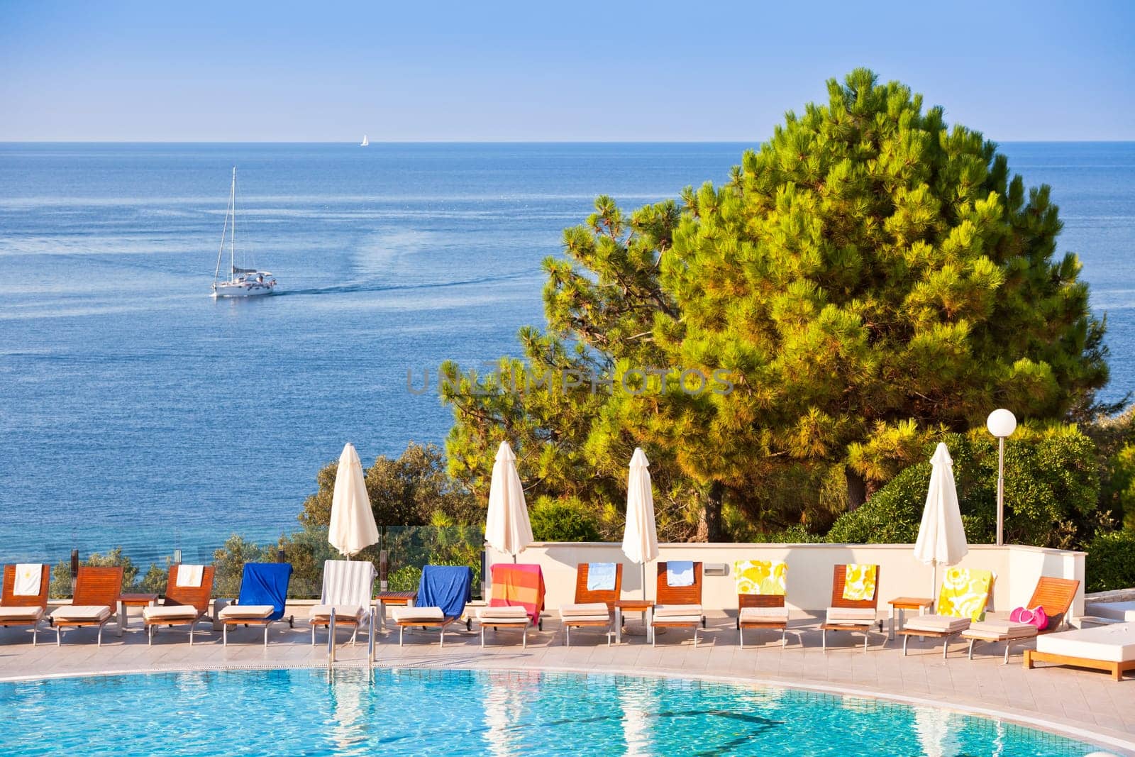 Sunbeds and umbrellas by the swimming pool on a sunny day