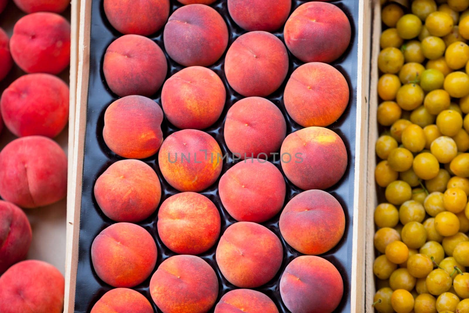 Fresh peaches and plums selling in a market. Horizontal shot with a selective focus