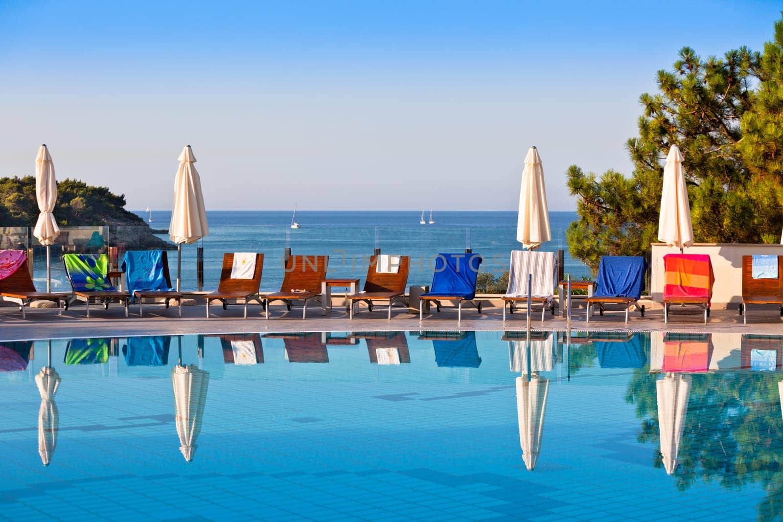 Sunbeds and umbrellas by the swimming pool on a sunny day