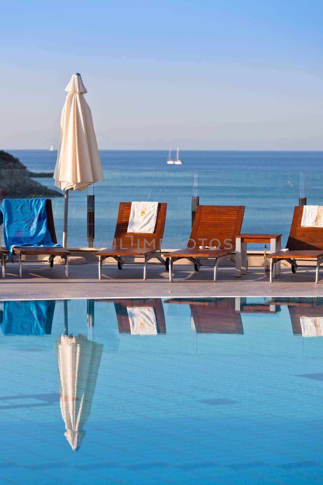 Sunbeds and umbrellas by the swimming pool on a sunny day