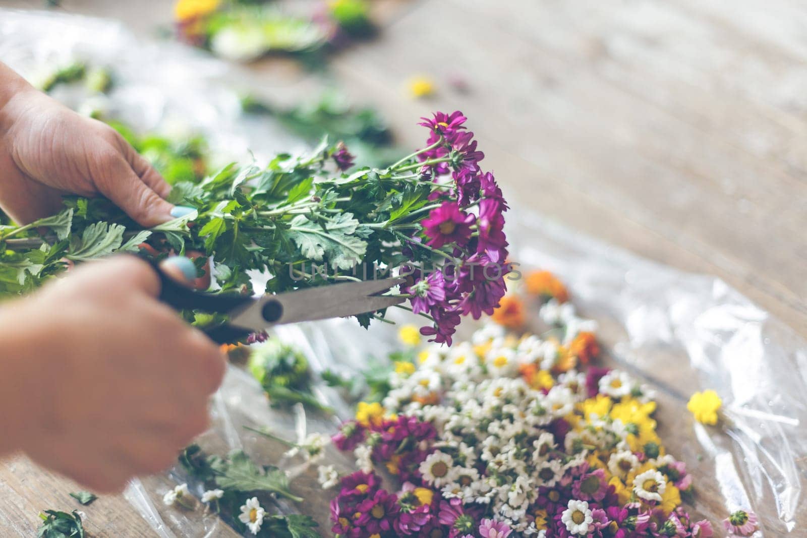 Florist making flower decoration. Indoors natural light shot with small depth of field