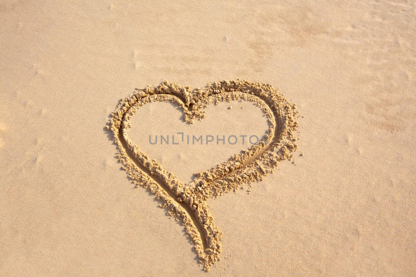 shape of heart paint on sea sand. horizontal shot