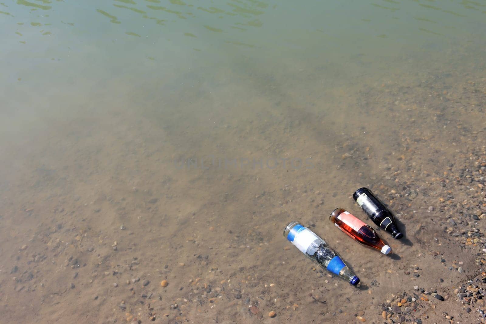 Cooling beverage bottles in a river in summer heat